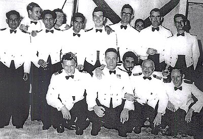 Aronda's officers during a BI anniversary party at Chittagong, September 15, 1956, including, from left front row, Chief Officer Henry Severs, Captain R S Freakes. ship's Surgeon (with pipe), Chief Engineer Officer W Oliver. Jack Hearne is second from right at the back with the Third Engineer on his left and Ist Radio Officer Dinjoe Murphy on his right